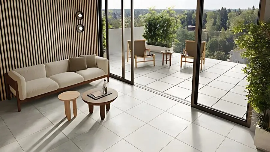 Płytki jasne podłogowe w salonie połączonym z tarasem przeszklonymi drzwiami rozsuwanymi